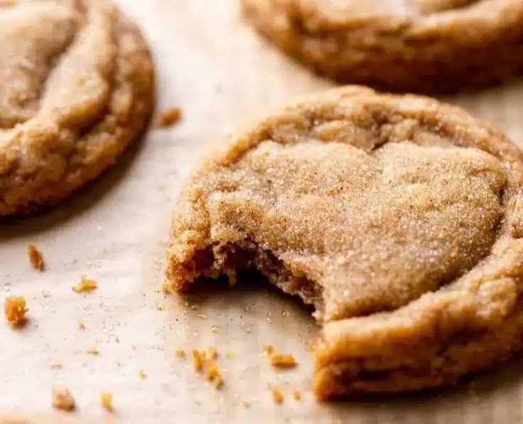 Chewy pumpkin cookies with spices and fall decorations on a wooden table.
