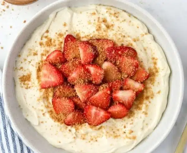 High protein cheesecake yogurt bowl topped with berries and nuts.