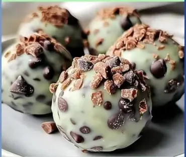 Mint chocolate chip protein balls stacked on a wooden table