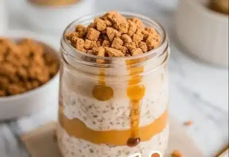 Bowl of Pumpkin Cheesecake Overnight Oats topped with spices and nuts.