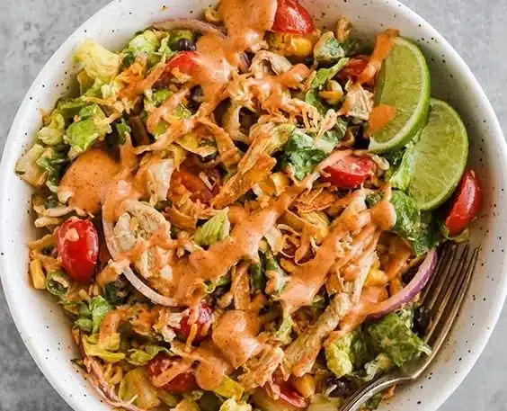 Colorful Taco Chicken Salad topped with fresh ingredients and served in a bowl